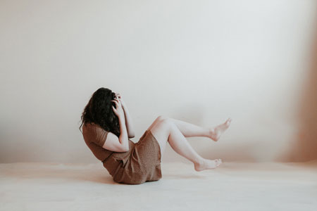Fotografía de una mujer en el suelo estirándose de los pelos